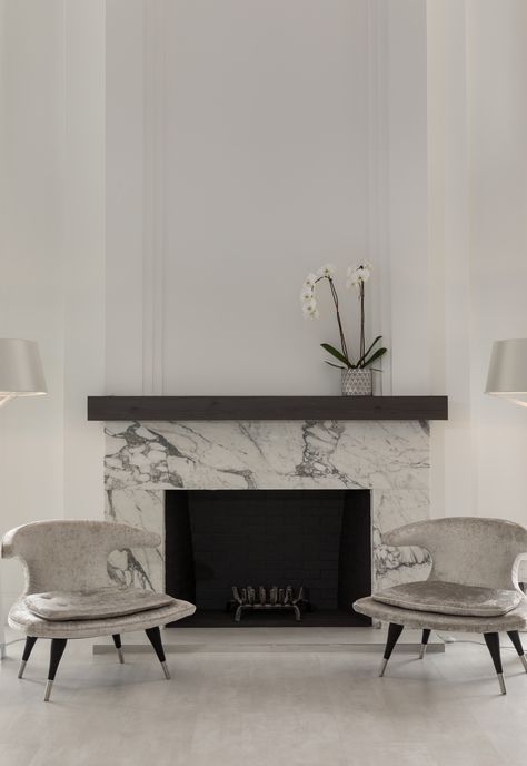 Tesoro Bianco Dolomite Fireplace project created using Dolomite Marble slabs from Primestones®, Premier Stone Provider in South Florida with locations in Miami and WPB. #tesorobianco #tesorobiancodolomite #bathroom #bathroomdecor #naturalstonecountertop #naturalstoneflooring #naturalstone #bathroominspiration #interiordesign New Classic Fireplace, Electric Fireplace With Marble Surround, Marble Fireplace With Mantle, Marble Fireplace With Wood Mantle, Marble Fireplace Ideas Modern, Marble Surround Fireplace, Fireplace Ideas Marble, Classic Fireplace Ideas, Marble Slab Fireplace