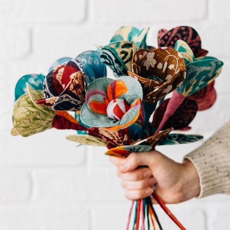 Hand crafted with a bendable wire stem, these flowers give upcycled sari fabric new life! Perfect on their own or as a bunch to liven up your home. This flower is easily wrapped or maneuvered into the shape of your choosing. Colors and patterns vary. Sold individually. Handmade in Bangladesh Materials: recycled cotton sari fabric, bendable copper wire Dimensions: total length: 14 in. long; flower is 3.5 in. D With every product you purchase, you are helping provide employment, educational opportunities and medical care to artisans in Bangladesh. Fabric Flower Stems, Upcycled Sari Ideas, Small Handmade Gifts, Upholstery Fabric Projects, Forever Bouquet, Recycled Fabric Art, Easy Fabric Flowers, Dining Room Centerpiece, Billy Buttons