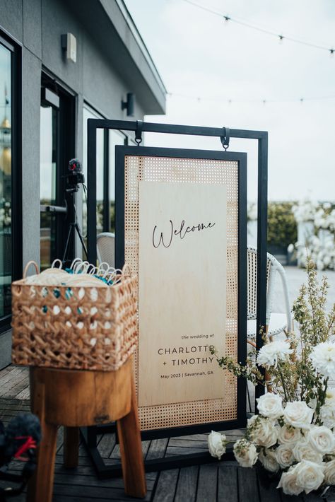 Black and rattan wood wedding welcome sign for a rooftop celebration in Savannah, Georgia. Planning by Plume Events and photo by 7Nine Photography. Rattan Wedding Invitation, Rattan Signage, Rattan Seating Chart, Unique Wedding Welcome Sign Ideas, Wood Wedding Signage, Rattan Wedding Decor, Diy Wood Wedding Signs, Unique Welcome Signs Wedding, Decor Rental Business