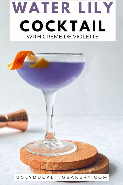 Purple Water Lily cocktail with orange twist in coupe on two stone coasters. The title reads, “Water Lily Cocktail with Crème de Violette” and the website is at the bottom. Lily Cocktail, Purple Recipes, Purple Velvet Cakes, Spring Drinks, Lavender Cookies, Spring Drink, Spring Cocktail, Purple Drinks, Lavender Syrup