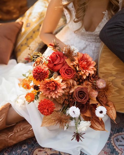 Orange can remind you of watching the sunset with the one you love, while red is the flickering flame inside your heart. When you use these colors in your bridal bouquet, they can help you capture warm, cozy, and even fiery vibes on your wedding day. Even just a sprinkle of orange or red can help you express passion an Red Tropical Bouquet, Red And Orange Flower Bouquet, Red And Orange Wedding Theme, Bridal Bouquet Ideas, Orange Bridal Bouquet, Orange Wedding Bouquet, Orange Wedding Themes, Winter Bridal Bouquets, Boho Wedding Theme