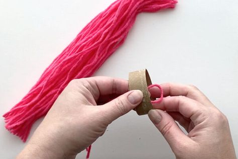 Placing the folded end of a piece of yarn through the cardboard tube. Gnome Projects, Gnomes Tutorial, Macrame Gnome, Gnome Craft, Christmas Macrame, Gnome Diy, Easy Macrame, Beard Shapes, Free Macrame Patterns