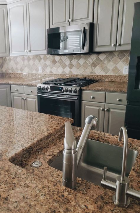 To remodel this kitchen we decided to paint the cabinets but keep the counter tops and backslash tile the same. Soft gray was the color we went with because it looked the best with our new hardware. I love the look it gives and the feeling of comfort. #contemporary #ideas #inspiration #remodel #makeover #repaint #painted #cabinets #softgray #beforeandafter #kitchenremodel #granitecountertops #tilebacksplash #paintcabinets #repaintingcabinets #kitchencabinetspainted #graycabinets #repaintcabinets Brown Faux Granite Countertops Kitchen, Grey Cabinets With Brown Countertops, Gray Tan Kitchen Cabinets, Brown And Gray Countertops, Charcoal Kitchen Cabinets With Brown Granite, Sage Green Kitchen Cabinets With Brown Granite Countertops, Gray Cabinets With Brown Granite, Kitchen Cabinet Paint Colors With Brown Countertops, Gray Kitchen Cabinets With Brown Granite