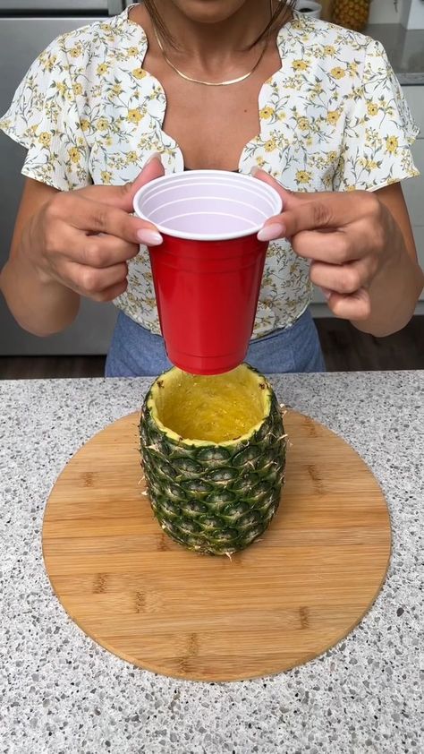 Pineapple Vase Trick | vase, Ananas comosus | We didn't know you could do this with a pineapple 🍍 | By The Shaba Kitchen | Facebook | Place your cup inside of a pineapple. And then I'm going to go ahead and fill it up about halfway with some fresh water. Next I'm going to take some scotch tape and just place that in the center of our cup. I'm going to take another piece and just place that right behind. And one more for the front. Now going the other way I'm going to place one piece of tape ove Flowers With Fruit In Vase, Mexican Themed Centerpieces, Pineapple Centerpiece Ideas, Fruit Centerpiece Ideas, Hawaiian Centerpiece Ideas, Hawaiian Centerpieces, Palm Springs Pool Party, The Shaba Kitchen, Pineapple Centerpiece