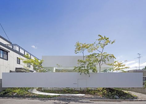 A narrow white wall appears to hover around the perimeter and garden of this house and atelier. Uid Architects, Cantilever Architecture, Japan Architecture, White Tone, High Walls, Japanese Architecture, Minimalist Architecture, Bisque Doll, Japanese House