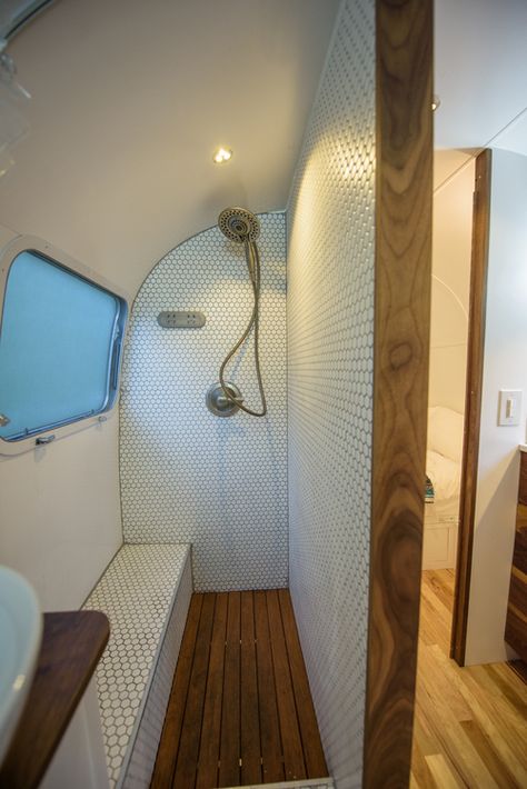 Gorgeous bathroom shower design and built by Townsend Travel Trailers. Teak floors and hexagon tile make for a great combination in this renovated vintage airstream trailer. Airstream Bathroom, Bus Conversions, Airstream Remodel, Airstream Interior, Bus Living, Rv Bathroom, Airstream Renovation, Teak Flooring, Caravan Renovation