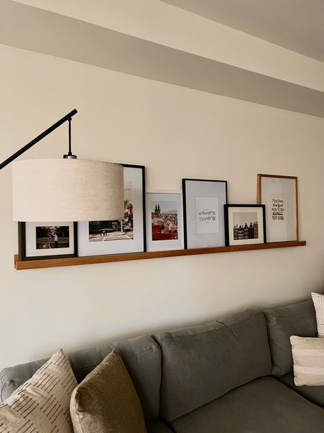 Behind the couch apartment inspo Pictures Above Sectional Couch, Photo Wall Living Room Above Couch, Sofa With Painting Above, Wall Decorations Behind Couch, Family Photo Wall Behind Couch, Corner Couch Pillow Arrangement, Lamp Behind Couch Corner, Behind Couch Lamp, Corner Couch Decor