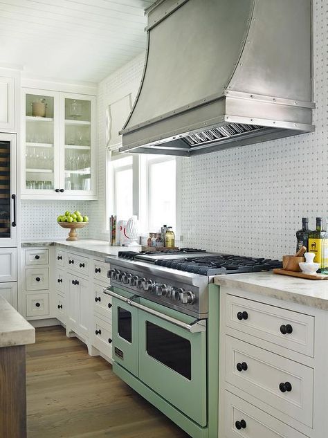 Beach style kitchen features a shiplap ceiling placed over white cabinets adorned with oil rubbed bronze hardware paired with honed white marble countertops and a black and white marble tile backsplash. Oven Nook, Watersound Florida, Colored Stove, Kitchens Cabinets, Marble Countertops Kitchen, Green Kitchen Cabinets, House Of Turquoise, Beach Kitchens, Countertop Design