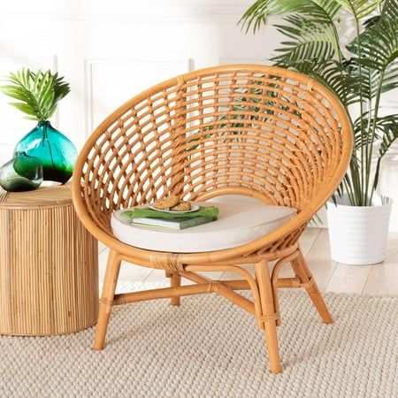 Indulge in an air of leisure with the lovely Aerin accent chair. Made in Indonesia, this bohemian piece is handcrafted from natural rattan by skilled artisans. Its openwork frame is interlaid with rattan pole to showcase the wonderful craftsmanship of the piece while the rounded silhouette creates a striking display. The Aerin will arrive fully assembled and features a cozy seat cushion to encourage carefree relaxation. With stunning visuals and remarkable comfort, the Aerin accent chair beautifully embellishes any layout. Disclaimer: Rattan is a product of nature and may have variations in areas such as, but not limited to, color, pattern, grain and texture. The hair-like strands of rattan/rattan-fiber are common due to the nature of the material. Overall: 33.10" W x 28.30" D x 31.90" H; Boho Accent Chair, Rattan Accent Chair, Cozy Seats, Farmhouse Traditional, Wood Sample, Vanguard Furniture, Chair And A Half, Rustic Lodge, Upholstered Side Chair