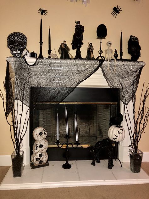 A fun and easy creation for a simple black and white mantle. Skeleton Mantle Decor, Halloween Garland Mantle Diy, Black Garland Halloween, Mantle With Tv, Halloween Skull Mantle, Halloween Mantle Scarf, Mantle Scarf, Black Mantle, White Mantle