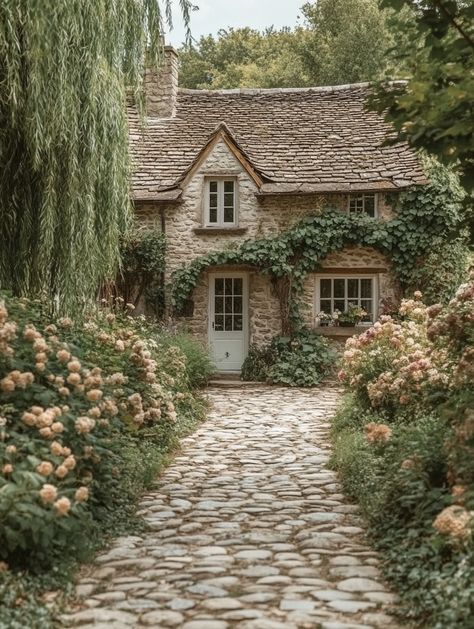 This picturesque stone cottage is enveloped in greenery, featuring lush climbing plants and vibrant flower beds along a charming cobblestone pathway. The cozy home, with its quaint windows and rustic roof, is surrounded by a serene garden setting, evoking a sense of tranquility and timeless beauty in nature's embrace. A perfect example of old-world charm, ideal for those who appreciate cottage aesthetics..  #cottage, #garden, #landscape, #rustic, #homestyle, #nature Stone Wall Cottage, Cottagecore Cottage Exterior, Cottage In France, Victorian Cottage Aesthetic, Cottage Vibes Aesthetic, Cabin Aesthetic Exterior, Castle Garden Aesthetic, Old Garden Aesthetic, Old Cottage Aesthetic