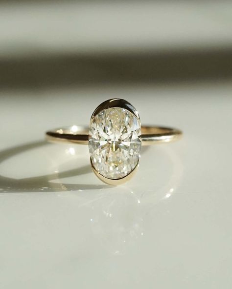 Bezel Set 1 Ct Oval Cut Moissanite Engagement Ring, Oval Cut Ring, Elongated Oval, Moissanite Engagement Ring, Ice Crushed Oval ✥ 𝐌𝐚𝐢𝐧 𝐒𝐭𝐨𝐧𝐞 𝐃𝐞𝐭𝐚𝐢𝐥𝐬 ↣ Shape: Oval Cut ↣ Type: Moissanite ↣ Weight: 1 Ct (App.) (8.19 x 5.64 x 3.36mm) ↣ Side Stone: Moissanite ↣ Color: Colorless ↣ Clarity: VVS ↣ Making Process: Handmade - Crafted by our experienced team ✥ 𝐑𝐢𝐧𝐠 𝐃𝐞𝐭𝐚𝐢𝐥𝐬 ↣ Band Width: 1.6 mm (± 0.10) [Customization Possible] ↣ Metal Purity: Solid Gold (10KT, 14KT, 18KT); Silve Half Bezel Ring, Half Bezel Setting, Oval Cut Moissanite Engagement Ring, Half Bezel, Gold Anniversary Rings, Oval Cut Ring, Wedding Rings Solitaire, Oval Moissanite, Moissanite Diamond Rings