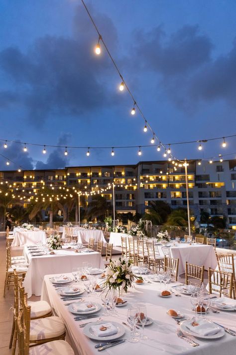 An evening wedding reception lit by market lighting. The tables are classic white with gold chairs. Dreams Natura Cancun Wedding Reception, Cancun Beach Wedding, Dreams Natura Cancun Wedding, Nighttime Outdoor Wedding, Dreams Natura Cancun, Cancun Wedding Reception, Cancun Destination Wedding, Mexico Wedding Venue, Small Beach Weddings