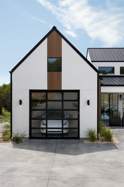 Stand out from the crowd with glass front garage doors! Nichiha wood look paneling + black metal roof with white stucco exterior. Park your Tesla in style! Project: Breakwater Scandinavian Architect: Danze + Davis Architects Designer: Claire Zinnecker Photographer: Cate Black Photography Exterior Beach House, Scandinavian Exterior, Black Metal Roof, Pass Through Window, Stone Feature Wall, Garage Pictures, Scandinavian Farmhouse, Steel Doors And Windows, Farmhouse Scandinavian