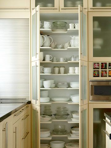 Maximize your kitchen's storage potential with floor-to-ceiling cabinets. Here a wall of cabinets with frosted-glass doors creates an open, modern look while concealing any bits of clutter. Inside the cabinets, each shelf has a U-shape cutout in the middle. The design makes it easy to see and reach both deep and shallow kitchen items. Small Kitchen Cabinet Storage, Kitchen Cabinets To Ceiling, Cabinets To Ceiling, Floor To Ceiling Cabinets, Casa Clean, Small Kitchen Cabinets, Hacks Kitchen, Kitchen Storage Space, Small Kitchen Organization