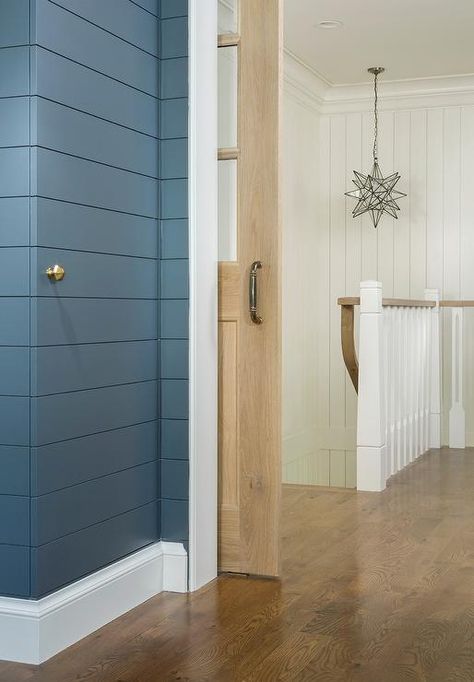 A blue mudroom, fitted with a door with a brass knob hidden behind a blue tongue and groove trim, is located behind a light stained oak pocket door with glass panes. Vertical Shiplap Hidden Door, Shiplap Wall With Secret Door, Hidden Shiplap Door, Hidden Shiplap Wall Storage, Hidden Doors In Wall Panel Bathroom, Shiplap Staircase, Blue Mudroom, Jib Door, Room Wardrobe