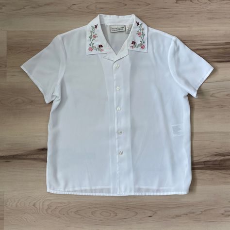 Brand: jaclyn smith collectibles. In excellent condition, no flaws. White 100% slightly sheer polyester fabric, very lightweight. Beautiful embroidered flowers on the collar. Boxy fit with short sleeves. Button down closure in front, no stretch to fabric. Shoulders: 15.5" Pit to pit:20" Waist: 19.5" Shoulder to hem: 23" #cottagecore #embroidery #flowers #blouse #vintage #90sfashion #librarian #floral Embroidery White Shirt, Embroidered Button Down, Embroidered Button Up Shirt, Cottagecore Embroidery, Halloween 23, White Linen Shirt, Embroidered Collars, Jaclyn Smith, Fits With Shorts