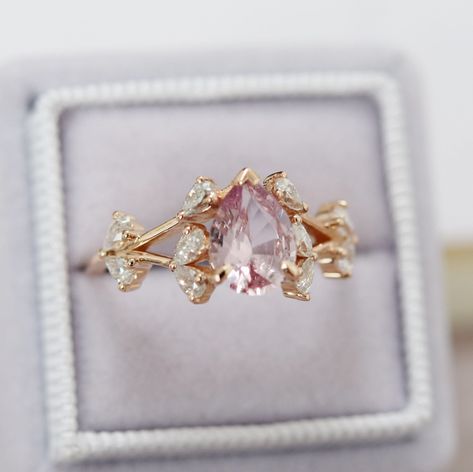 "Peach pink Sapphire ring. Multi-stone ring. Butterfly meadow cluster ring. Rose gold engagement ring with sapphire and moissanites. The ring features pear cut natural sapphire in peach pink color, 1.5ct, 6x8mm. The cut is mesmerising, making the stone sparkle like crazy. The color is fantastic. It is a blend of blush and peach. It changes constantly depending on the lightening and shines all over the place. The aquamarine is set in our OOAK dragonfly setting 14k rose gold, accented stones are m Engagement Ring With Pink, Pink Dainty Engagement Ring, Peach Stone Engagement Ring, Wedding Ring With Pink Stone, Vintage Pink Rings, Pink Butterfly Ring, Pink And Gold Wedding Ring, Vintage Pink Sapphire Ring, Pink Stone Wedding Ring