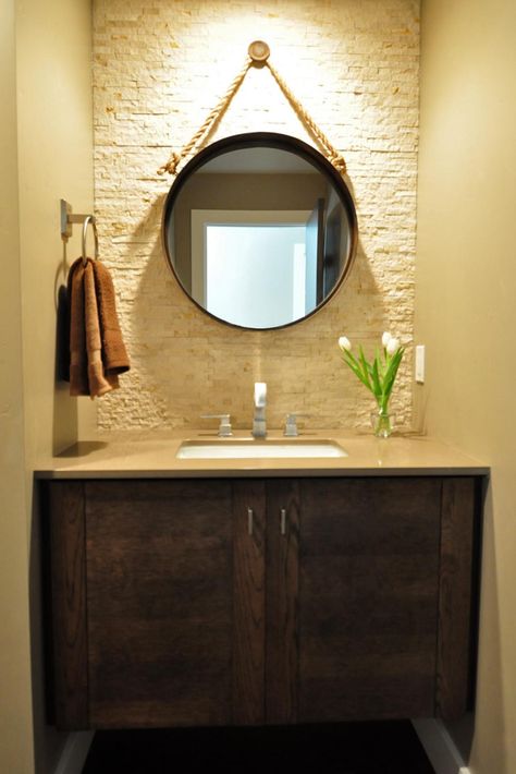 A circular mirror with a rope hanger creates major impact in this small powder room — and adds a bit of a nautical flair. The tiled wall the same color as the side walls brings a subtle texture and heightened interest to the space. Clean lines throughout keep the room from feeling busy. Contemporary Powder Room, Antique Bathroom Vanity, Floating Bathroom Vanities, Washbasin Design, Storage Inspiration, Bathroom Remodel Tile, Diy Bathroom Remodel, Circular Mirror, Bathroom Remodel Shower