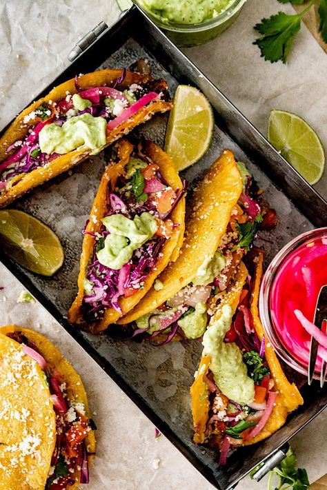 Black Bean Tacos served in crispy taco shells with creamy avocado sauce, pickled red onions, shredded cabbage, and cheese. Cabbage And Cheese, Crispy Taco Shells, Fresh Corn Salad, Grilled Taco, Dinner Favorites, Creamy Avocado Sauce, Crispy Tacos, Black Bean Tacos, Taco Shells