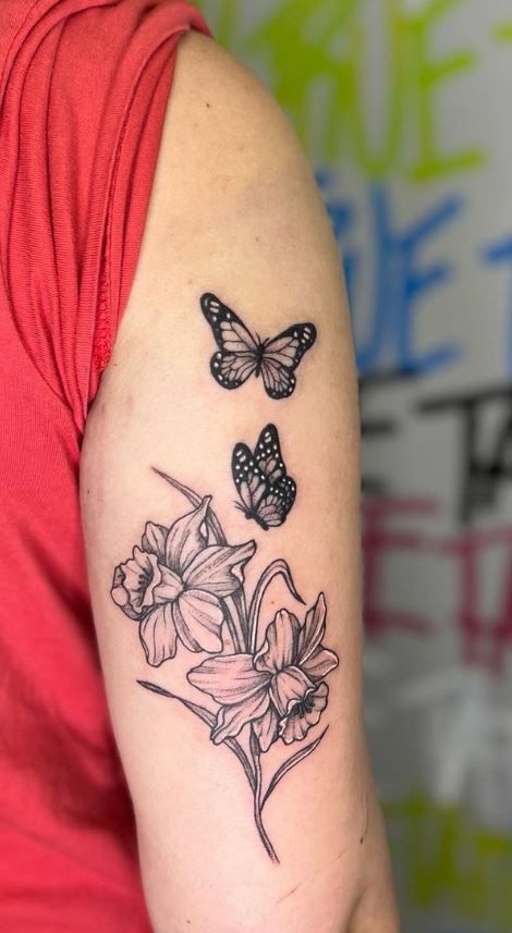 Daffodil Tattoo Wrap Around Wrist, Butterfly With Daffodil Tattoo, Marigold And Butterfly Tattoo, Daffodil And Carnation Tattoo, Daffodil Tattoo Black And White, Daffodil Butterfly Tattoo, Daffodil And Butterfly Tattoo, Dafadills Tattoo Design, Daffodil Tattoo Sleeve