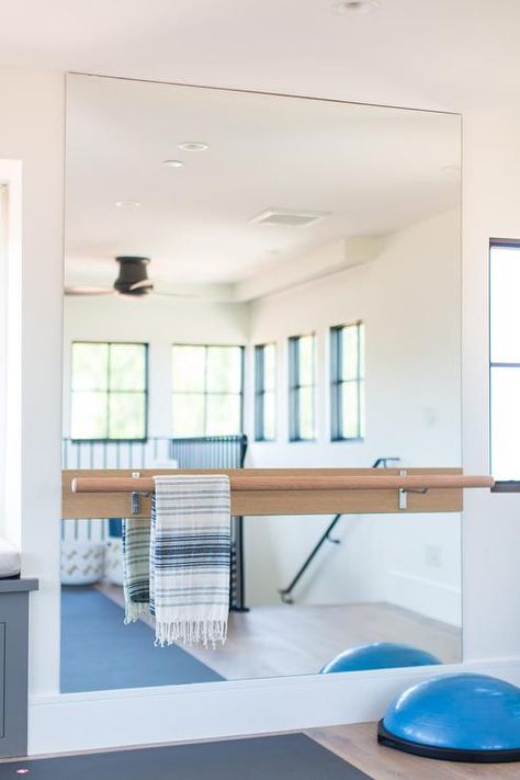 Ballet barre mounted on a large frameless mirror in a home gym featuring space for yoga and other various exercises uses. Home Gym Design Basement, Home Gym Mirrors, Home Dance Studio, Home Yoga Room, Home Gym Basement, Home Gym Garage, Workout Room Home, Gym Mirrors, Dance Rooms