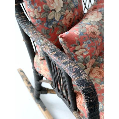 This is an antique wicker rocking chair.  The black wicker arm chair features a spring seat base with a pink floral cushion and two small matching throw pillows. Black Wicker, Wicker Rocking Chair, Antique Wicker, Floral Upholstery, Black Tears, Windsor Chair, Floral Cushions, Copper Wall, Blanket Wrap