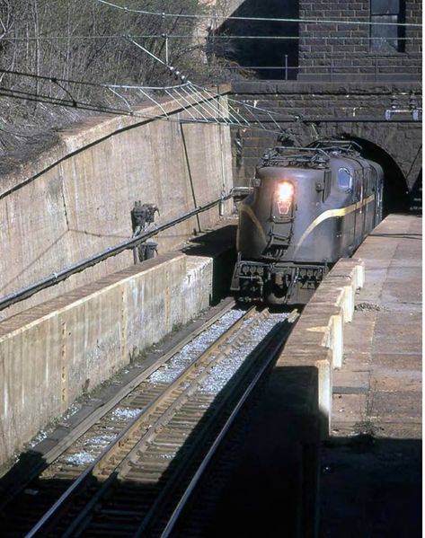 1961 sees a GG1 exiting the North River Tunnel, North Tube. The portal house above the portal and the third rail give it away, along with the high concrete walls. Lionel Trains Layout, Union Pacific Train, Ho Scale Train Layout, Third Rail, Railroad Art, Commuter Train, Penn Station, Concrete Walls, Railroad Pictures