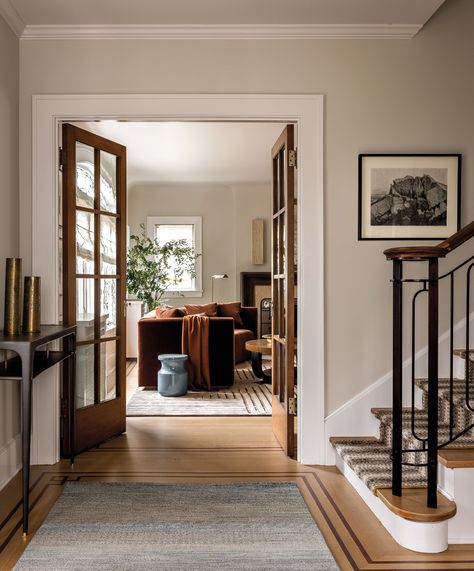 When reviving a century-old home in Seattle, designer Charlie Hellstern focused on celebrating existing finishes with complementary details. Alongside original hardwood floors is an Ochre console. A peek into the living room reveals a bespoke Rogers & Goffigon-upholstered sofa. Walnut Flooring, Wood French Doors, Custom Light Fixtures, Seattle Homes, Walnut Floors, Walnut Furniture, Foyer Design, Beautiful Rooms, Luxe Interiors