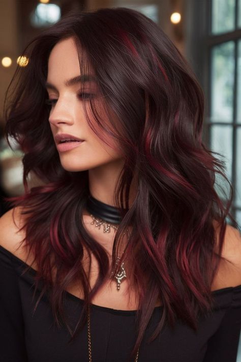 For those looking to make a bold statement, this edgy dark hairstyle features vibrant red highlights subtly blended into wavy layers. The contrast between the deep base color and the bright red accents creates a striking look that’s perfect for those with a daring sense of style. Ideal for adding a pop of color without overwhelming the overall look, this hairstyle offers a fresh and youthful vibe. Dark Hair Red Highlights, Deep Winter Hair Color, Chocolate Brown Balayage, Dark Hair Color Ideas, Bright Red Highlights, Dark Hair Color, Hair Color Ideas For Winter, Dark Waves, Dark Red Hair Color