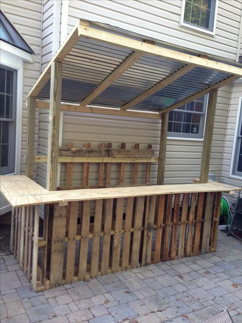 Construction is complete...base made with 3.5 pallets, rear wall is two more pallets and 2x4s, bar is 3/4 inch plywood, and roof is 3 sheets of corrugated tin Diy Grill Island, Bar Pallet, Bar En Palette, Pallet Bar Diy, Diy Outdoor Bar, Bar Diy, Bar Exterior, Outside Bars, Bar Outdoor