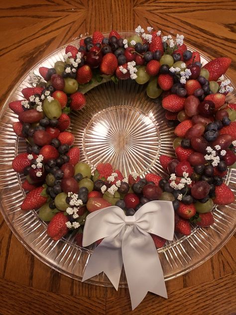 Base is a floral wreath. Use toothpicks for the fruit, starting with the larger fruits, such as strawberries. Fill in and decorate with bow and babies breath. Wreath Fruit Tray, Christmas Fruit Wreath, Fruit Trays, Fruit Wreath, Charcuterie Inspiration, Christmas Fruit, Babies Breath, Berry Fruit, Xmas Food