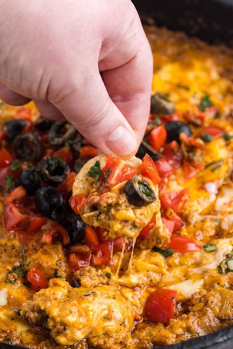 dipping cracker into cheesy taco dip. Crockpot Nacho Dip, Taco Dip Crock Pot, Crockpot Taco Dip Ground Beef, Ground Beef Taco Dip Recipe, Chicken Taco Dip Recipe, Warm Taco Dip With Ground Beef, Warm Taco Dip, Crockpot Taco Dip, Cheesy Taco Dip