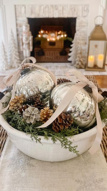 Jenny Brooks • Bloom Interior Designs on Instagram: "Easy centerpiece idea! ✨ And the best part is these fabulous oversized mercury ornaments are on sale for $15! Grab a large bowl, some greenery, 2 ornaments, pinecone filler, and ribbon…because bows make everything better! 🤍 I linked the ornaments and several bowl options for you. Just tap the link in my bio for details… #holidaycenterpiece #christmastabledecor #centerpiecesideas #christmasdecor #holidayhomedecor #christmascenterpiece #coffeetablestyling" Bread Bowl Decor Centerpieces Winter, Ornament Arrangement Ideas, Christmas Bowl Centerpiece Ideas, Christmas Bowl Fillers Ideas Centerpieces, Coastal Christmas Centerpiece Ideas, Ornaments In Bowl Decor, Coffee Table Bowl Filler, Christmas Dough Bowl Table Centerpieces, Large Decorative Bowl Filler Ideas