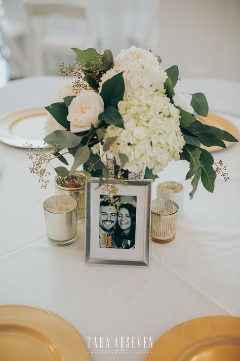 | modern wedding centerpiece | gold + white wedding reception decorations | white wedding flower centerpiece | gold wedding table settings | elegant wedding centerpiece with flowers + small candles | brides of north texas | photo taken at THE SPRINGS Event Venue. follow this pin to our website for more information, or to book your free tour! SPRINGS location: Rockwall Manor in Rockwall, TX photographer: Kevin Paul Photography #weddingcenterpiece #weddingdecor #weddingdecorations #whiteweddings Wedding Table Picture Centerpieces, Wedding Table Decor With Pictures, Ivory And Gold Centerpieces, Wedding Centerpieces With Pictures, Picture Centerpieces Wedding, Picture Centerpiece Ideas, Wedding Table Settings Elegant, Small Floral Centerpieces, Candle Table Setting