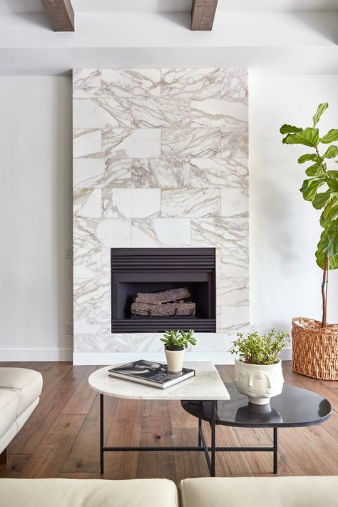 Create a stunning feature piece in your home with natural stone. Featured here on the fireplace surround is Calacatta Gold Polished 12 x 24 marble tile. Tap the photo to learn more. #marbletile #whitemarble #fireplacedesigninspo #arizonatile #fireplacedesignideas White Marble Tile Fireplace, Marble Tile Fireplace Surround, Marble Tile Fireplace, Tile Fireplace Surround, Marble Living Room, Arizona Tile, Living Room Transitional, Marble Fireplace Surround, Tile Fireplace