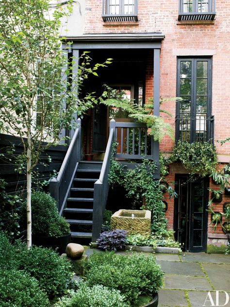 The painted trim of the 1905 house is complemented by matte-black accents found throughout the garden; the window box is planted with English ivy, and a purple sweet potato vine adds a splash of color at the foot of the stairs. Stair Solutions, Townhouse Garden, Brick Exterior, Black Windows, Contemporary Garden, White Garden, Julianne Moore, City Garden, Brick Building