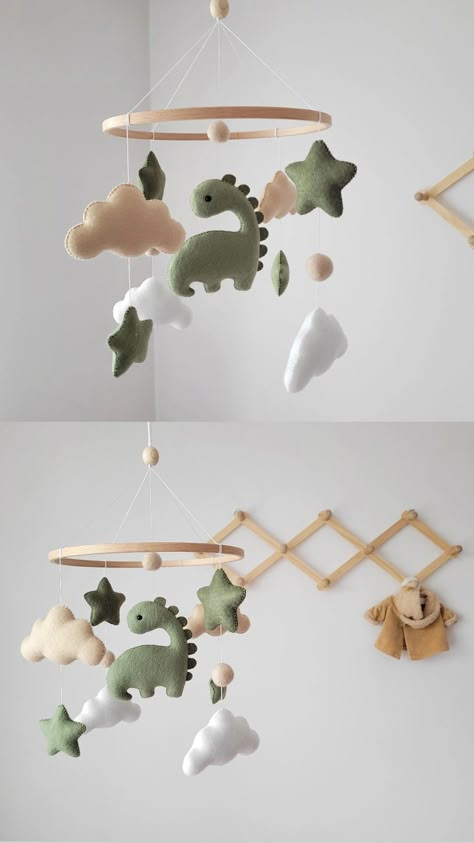 Adorable felt baby mobile featuring a charming green dinosaur. 💚

This baby mobile is meticulously handmade with attention to detail, ensuring a high-quality and delightful addition to your nursery decor. It is crafted using safe and eco-friendly materials, making it a perfect choice for your little one. 🌿 Sage Dinosaur Nursery, Cute Dinosaur Nursery, Nursery Decor Dinosaur, Dinosaur Mobile Diy, Green Dino Nursery, Dinasour Themed Nursery, Baby Nursery Dinosaur Theme, Nursery Ideas Dinosaur Theme, Dinosaur Theme Nursery For Boys