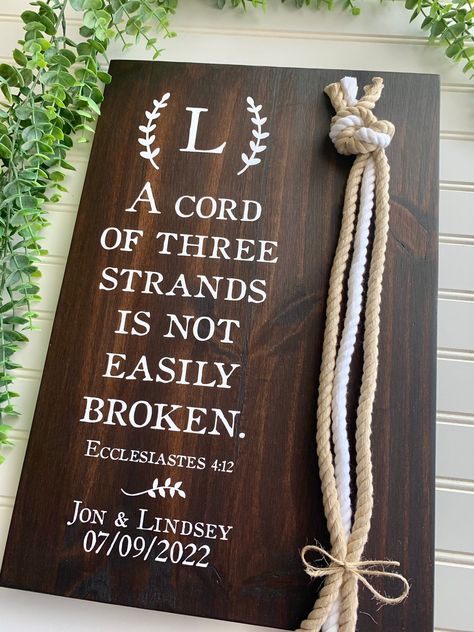 "Please click here for important shop info before ordering: https://www.etsy.com/shop/BeeAndBunnyDesigns A wonderful wedding gift, anniversary gift, or perfect for display on a table at a wedding or reception! This sign features the verse \"A cord of three strands is not easily broken\" (Ecclesiastes 4: 12). It also includes a lovely rope detail (2 natural cords and 1 white cord) appearing next to the verse. This sign comes in two sizes and is available in several stains options. We use permanen Cord Of Three Strands Wedding, Cord Of 3 Strands, Unity Braid, Braid Wedding, Cord Of Three Strands, Rustic Wedding Gifts, Ceremony Sign, Rustic Cross, Wedding Ceremony Signs