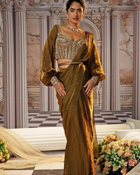 Just in, The Aphrodite, a collection which is a radiant tribute to the goddess within every woman, featuring lehenga sets and pre-draped sarees in luxurious, jewelled tones. The collection, with its rich colors and ornate design is perfect for a bride or bridesmaid to shine in this Autumn Winter Wedding Season Find it on Fabilicious 💞 WhatsApp us on +91 99992 89222 for any queries 🌟Made to Measure 🌟Personal service with VC for measurements 🌟 Trusted Brand #indianwedding #indiandesign... Saree Draping Styles Modern, Blouse With Sleeves, Draping Styles, Drape Sarees, Saree Draping Styles, Saree Draping, Corset Blouse, Embellished Belt, Gown Skirt