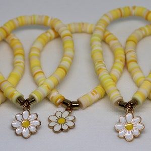 Clay bead bracelet with multiple colors of yellow beads and 2 gold spacer beads with a daisy charm in the middle Clay Bracelet Ideas, Elastic Bracelets, Clay Bead Bracelet, Bracelets Ideas, Yellow Bracelet, Daisy Charm, Daisy Bracelet, Yellow Daisy, Clay Bracelet