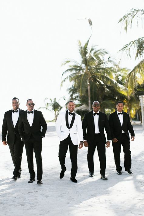 groomsmen in black and groom in white jacket Grooms In White Tuxedos, Black And White Tuxedo Wedding Groomsmen, White Groom Black Groomsmen, White And Black Groomsmen Attire, Bride And Groom In All White, Groom And Bride In White, Groom In White Jacket, Black And White Suit For Men Wedding, Bride And Groom White Attire