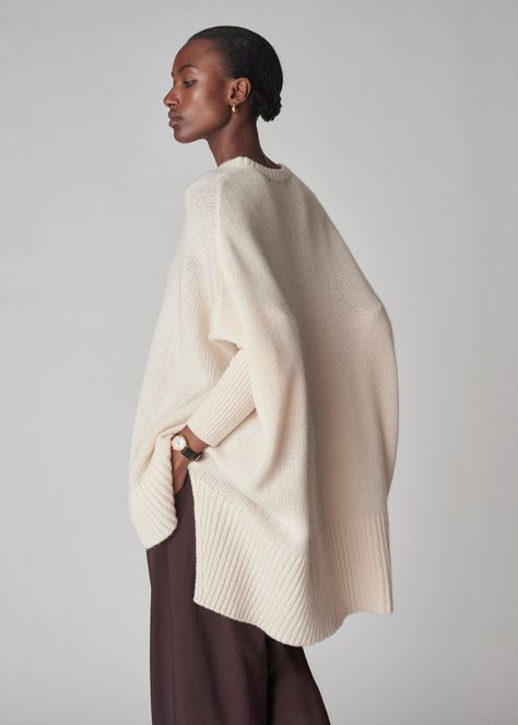 Wrap yourself in the luxurious softness with our poncho style sweater. Combining the sophistication of cashmere with a modern, relaxed silhouette. The fitted sleeves make it easy easy to move around in. Ribbed neck hem. Details 100% Cashmere Ivory 7701LNC-F24 Relaxed fit Model is 5'9" and wears a size small. Luxury Merino Wool Outerwear For Spring, Ivory Wrap Sweater, Luxury Winter Sweater, Luxury Soft Knit Cashmere Sweater, Luxury Merino Wool Soft Knit Sweater Coat, Luxury Alpaca Sweater For Fall, Batwing Sleeve Sweaters, Shall Sweaters, Luxury Cashmere Sweater