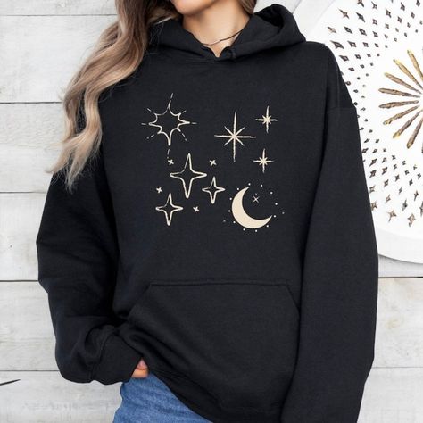 Available In Unisex S, M, L, Xl, And Xxl. Just Place An Order And Message Your Size After! Celestial Hoodie, Stars Sweatshirt, Cosmic Comfort Elevate Your Style With Our ""Celestial"" Hoodie! Made From Soft, Durable Fabric, This Hoodie Is Perfect For Stargazing Or Everyday Wear. It Features A Spacious Front Kangaroo Pocket, Adjustable Drawstring Hood, And Ribbed Cuffs For A Comfortable Fit. Whether You’re Out And About Or Relaxing At Home, This Hoodie Keeps You Cozy While Celebrating The Beauty Of The Cosmos. Material: 100% Cotton Made To Order With High-Quality Celestial Print. Etsy Hoodies, Celestial Hoodie, Moon Clothes, Space Clothes, Moon Sweater, Celestial Print, Heart Icon, Fabric Waste, Y2k Clothes