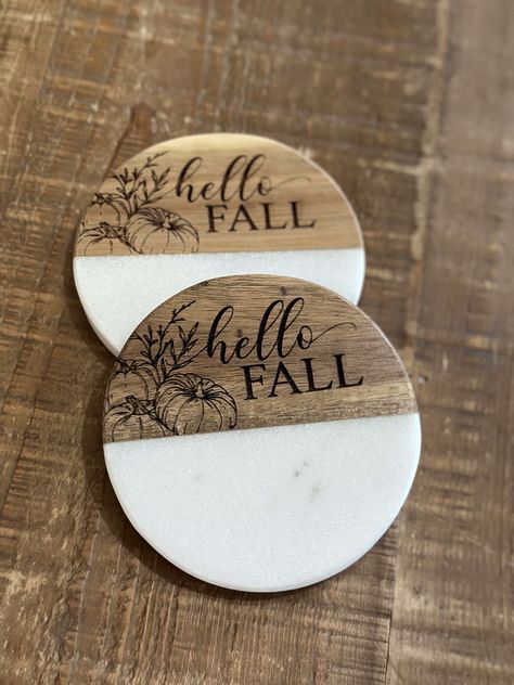 Coasters are a necessity for every home. Yours should reflect your style. Our wood and white coasters can be engraved to do just that: our sunflower coasters add a fall flair to any tabletop. Marble and wood Please note: Marble is a natural product. Variations in color, and texture, plus noticeable cracks and flaws are to be expected as that is the nature of the product Each coaster may be different in marbling and wood color. Measures 4" x 4" Wipe clean Includes foam bottom pads to protect furniture Imported Riser sold separately Style Coasters Finish Hello Fall Sunflower Dimensions 4 x 4 Design Marble and wood Please read our FAQ page prior to purchasing. Install the included handles and use a barrier between our tiered tray and food. Wood And Epoxy Coasters, Engraved Coaster Ideas, Coaster Engraving Ideas, Wood Burn Coasters, Wood Burning Coasters, Tv Stand And End Tables, Wood Burned Coasters, Thanksgiving Coasters, Door Rounds