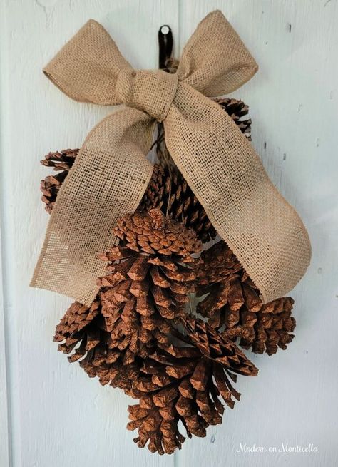 Pine Cone Door Swag, Pine Cone Door Hanger, Pine Cone Swags, Fall Pine Cone Decorations, Crafts With Large Pinecones, Pinecone Swag Diy, Crafts With Pine Cones, Gold Glitter Spray Paint, Glitter Door