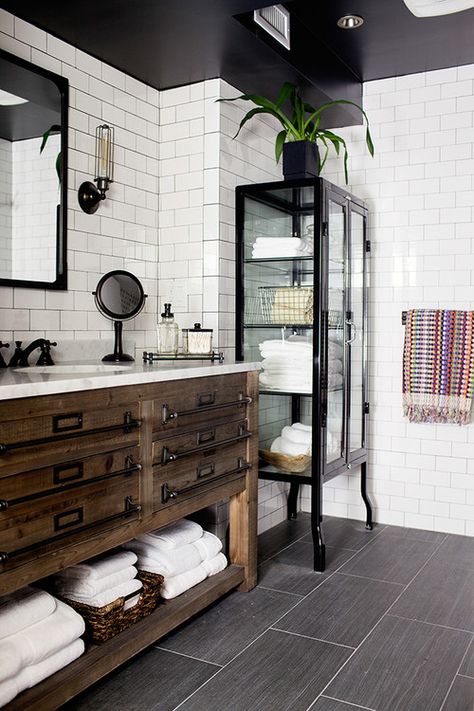 You can’t go wrong with the black and white paint pairing of this industrial-inspired bathroom. But the real standout in this space is the furniture. Elegant pieces such as this glass and black lacquer display cabinet can take your bathroom from average to inspired. Drømme Bad, Makeover Kamar Mandi, Beautiful Bathroom Vanity, Warm Industrial, Farmhouse Bathroom Decor Ideas, Industrial Inspiration, Industrial Bathroom, Bad Design, Farmhouse Bathroom Decor