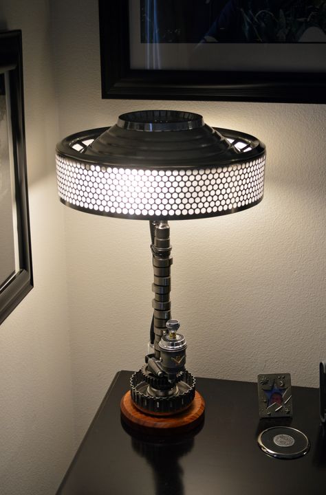 This lamp uses a camshaft cut down, and also has a 3-way rotary switch on the front, in a housing made from exhaust tubing and held on with a camshaft retaining bracket. This lamp also uses 2 60 Watt equivalent 120V LED bulbs in an S-shaped fixture. Car Part Art, Old Car Parts, Car Parts Decor, Diy Luminaire, Car Part Furniture, Automotive Furniture, Power Chair, Chair Parts, Car Furniture