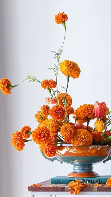 B L U E J A S M I N E on Instagram: "Local marigolds make friends with minty hard goods…. A somewhat unusual pairing but feels so right - like that perfect salty and sweet treat. 🍊👗 Pin frog @floralgeniusig | candles @yummicandles | blooms @gardenstateflowercoop … #njflorist #njflowers #florist #dslflowers #fineartflowers #floweraddict #moodforfloral #playingwithpetals #floralstories #petalsandprops #flowers #floraldesigner #floraldesign #weddingstyle #flowerpower #floristlife #florallove Marigold Flowers Wedding, Marigold Boutonniere, Day Of The Dead Marigolds, Marigold Floral Arrangement, Marigold Design, Marigold Arrangements, Marigold Decor, Marigold Flower Arrangements, Marigold Centerpiece