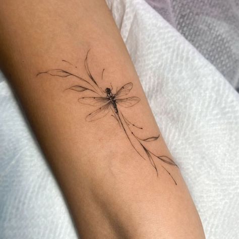 Fine line dragonfly tattoo on forearm Dragonfly Flower Tattoo Design, Elegant Dragonfly Tattoo, Feminine Fine Line Tattoo Ideas, Feather Flowers Tattoo, Animal Tattoos Fine Line, Dragon Fly Tattoo Ideas, Dragonfly Tattoo Elbow Crease, Daisy And Dragonfly Tattoo, Flying Dragonfly Tattoo